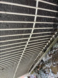 Eugene AC repair technician inspecting an indoor unit after water was found around HVAC equipment